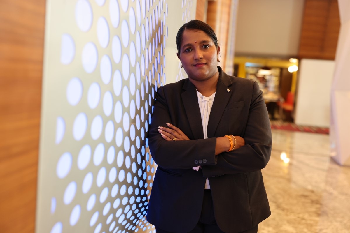 Shanta Vijiasundram, Sunway Pyramid Hotel’s long-tenured front office manager posing in front of the front lit wall at Sunway Pyramid Hotel.