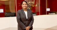 Shanta Vijiasundram, Sunway Pyramid Hotel’s long-tenured front office manager posing in front of the front office - adorned with glass panels and monitors) at Sunway Pyramid Hotel.