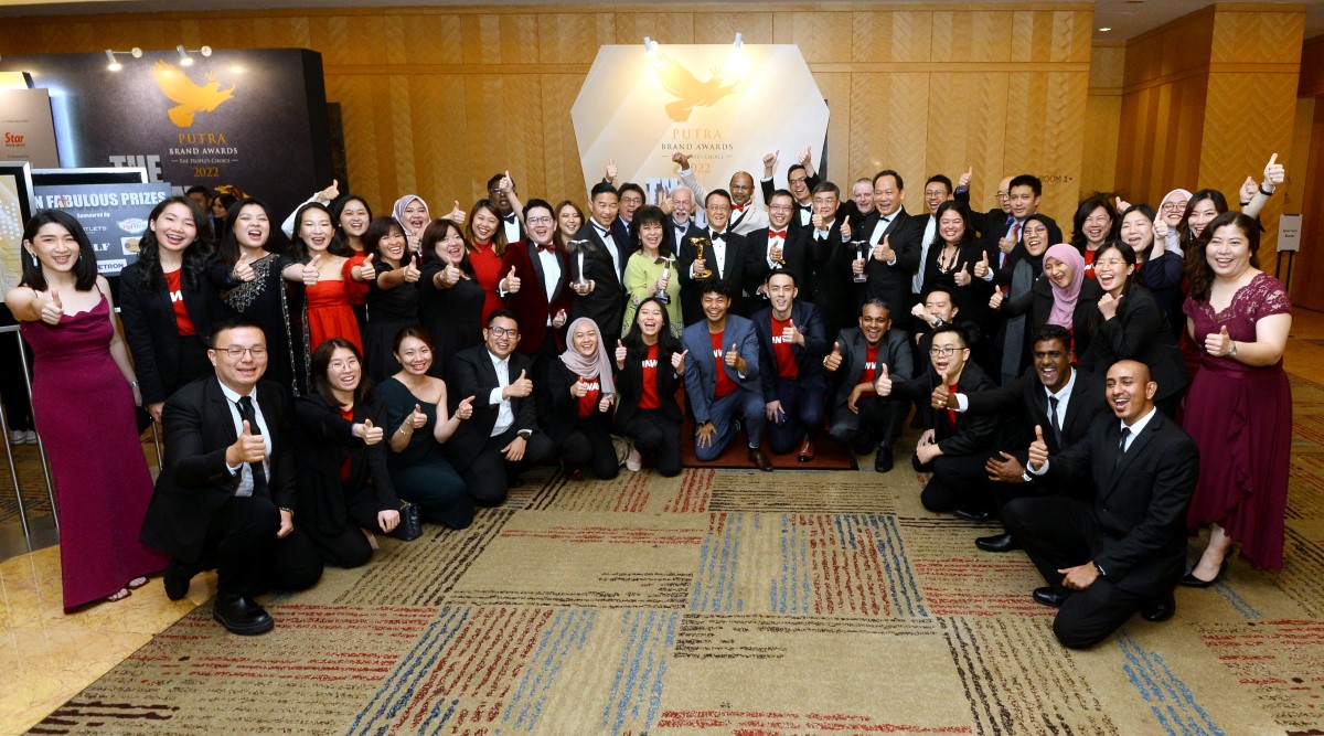 Sunway staff holding up the thumbs up sign at the Putra brand Awards, clad in Sunway red t-shirts and red-themed outfits.