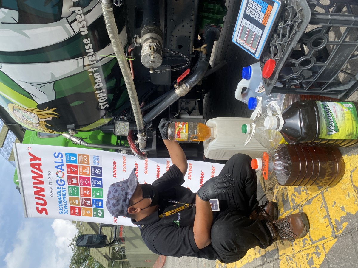 A portrait of a staff from FatHopes Energy dispensing donated used cooking oil into his tanker truck for proper storage before being transformed into biofuels.