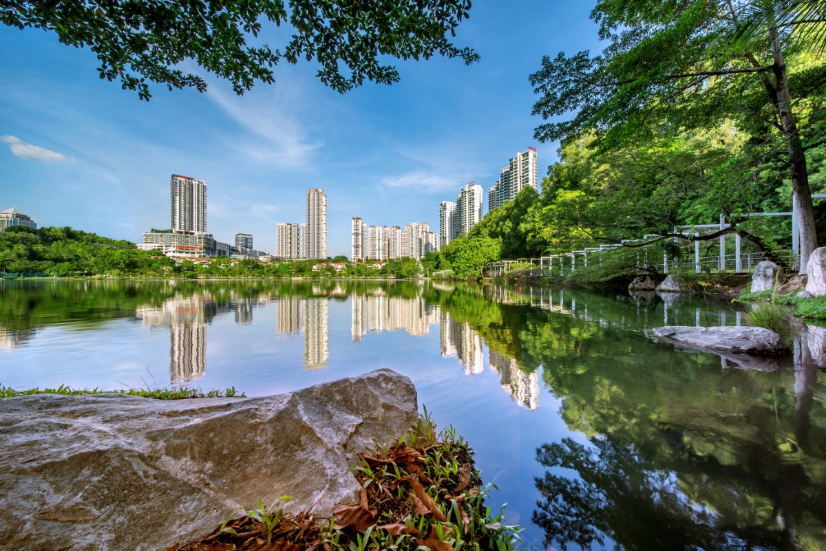 An on-ground view of Sunway South Quay lake, featuring a nice reflection of the Sunway City skyline with greeneries around it.