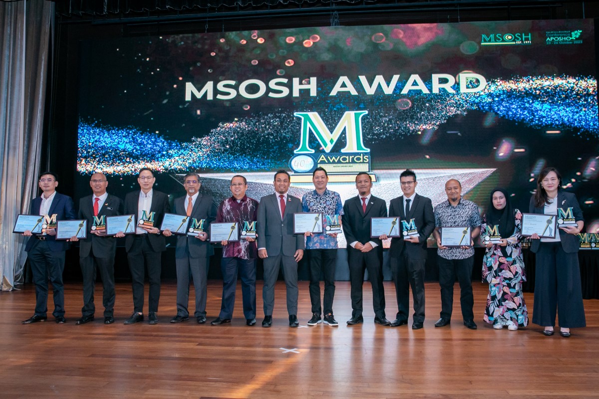 Sunway OHSE staff receiving their certificate at the MSOSH Awards, with wooden tiles and MSOSH Award in the background