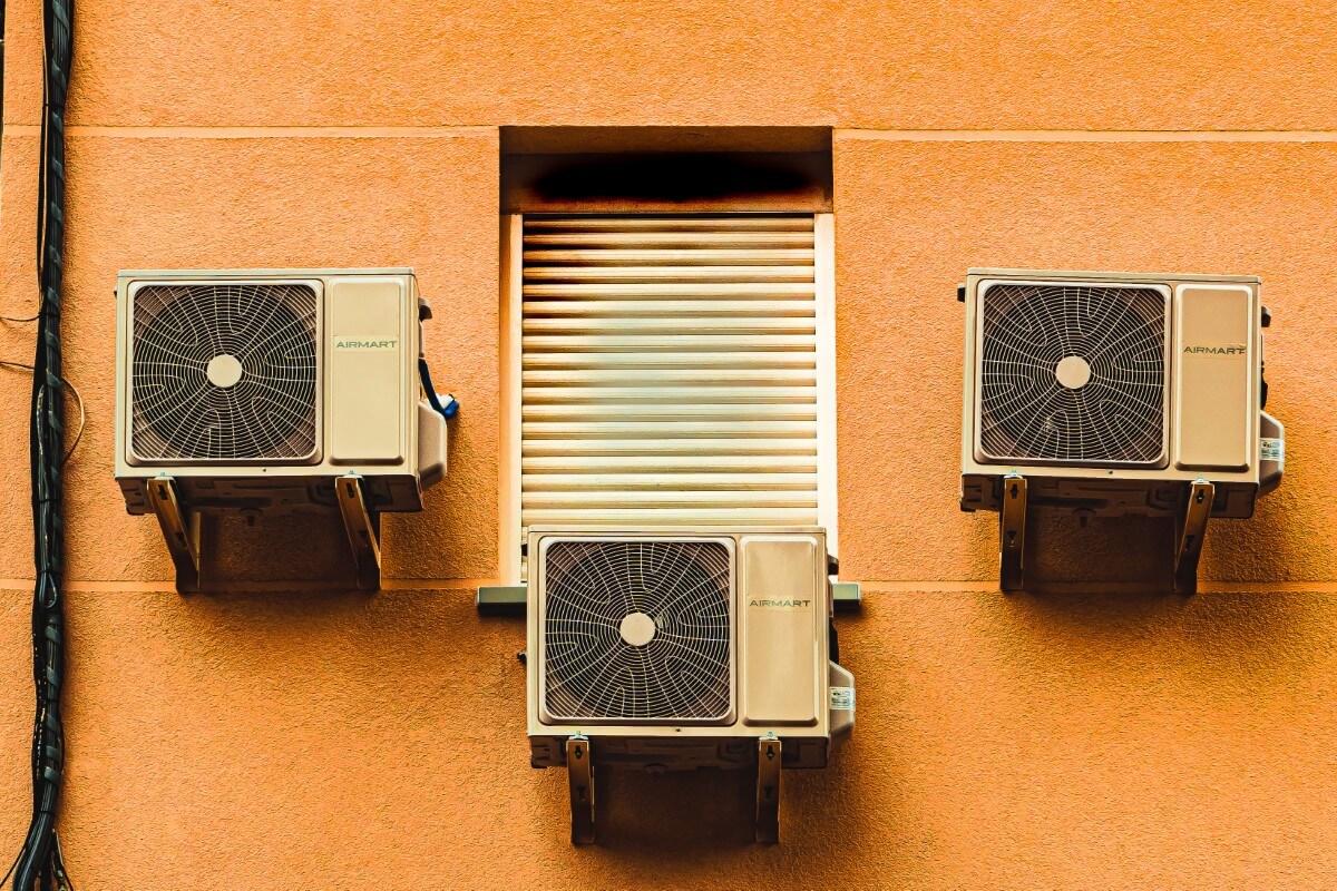 A landscape shot of three air-conditioning compressor units positioned side by side.