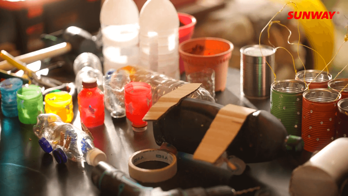 A close-up shot of bottles and plastics used for decorations, alongside cardboards and tape.