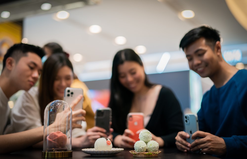 Group of young people taking photos of the confectioneries with their phones