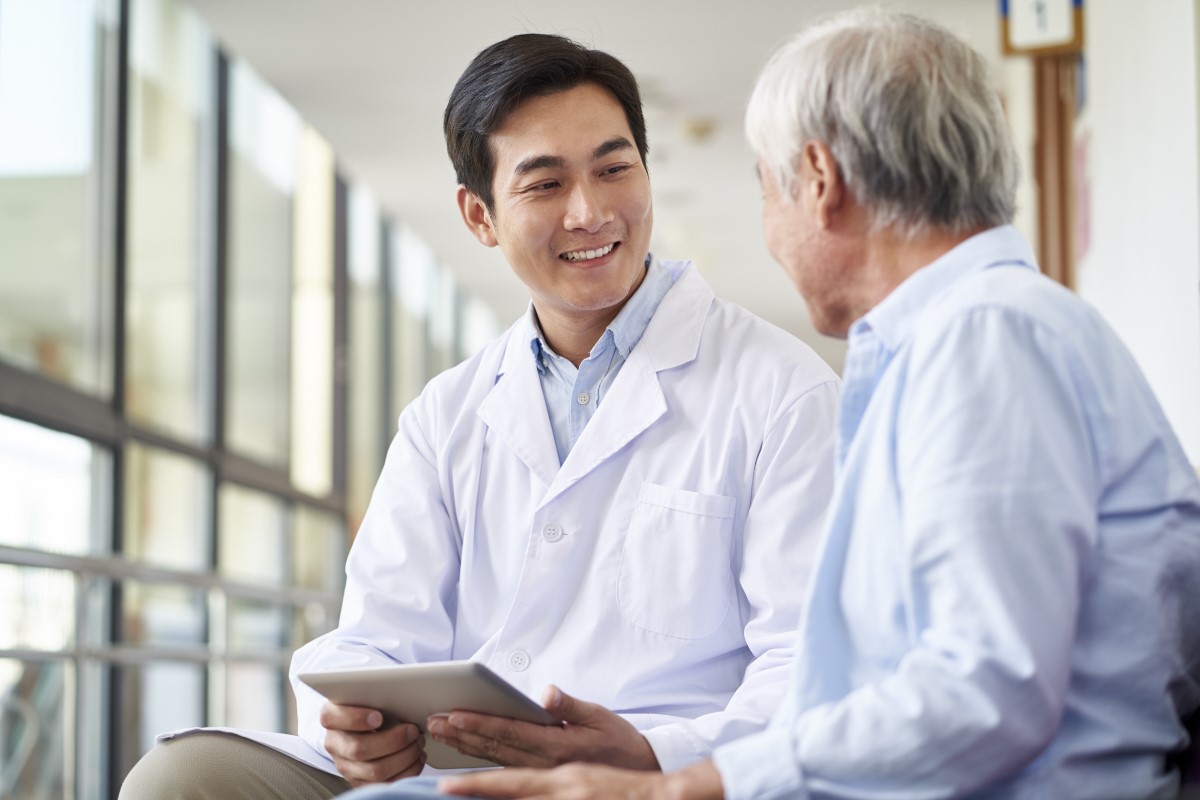 A medical doctor alongside an elderly patient at Sunway Medical Centre.