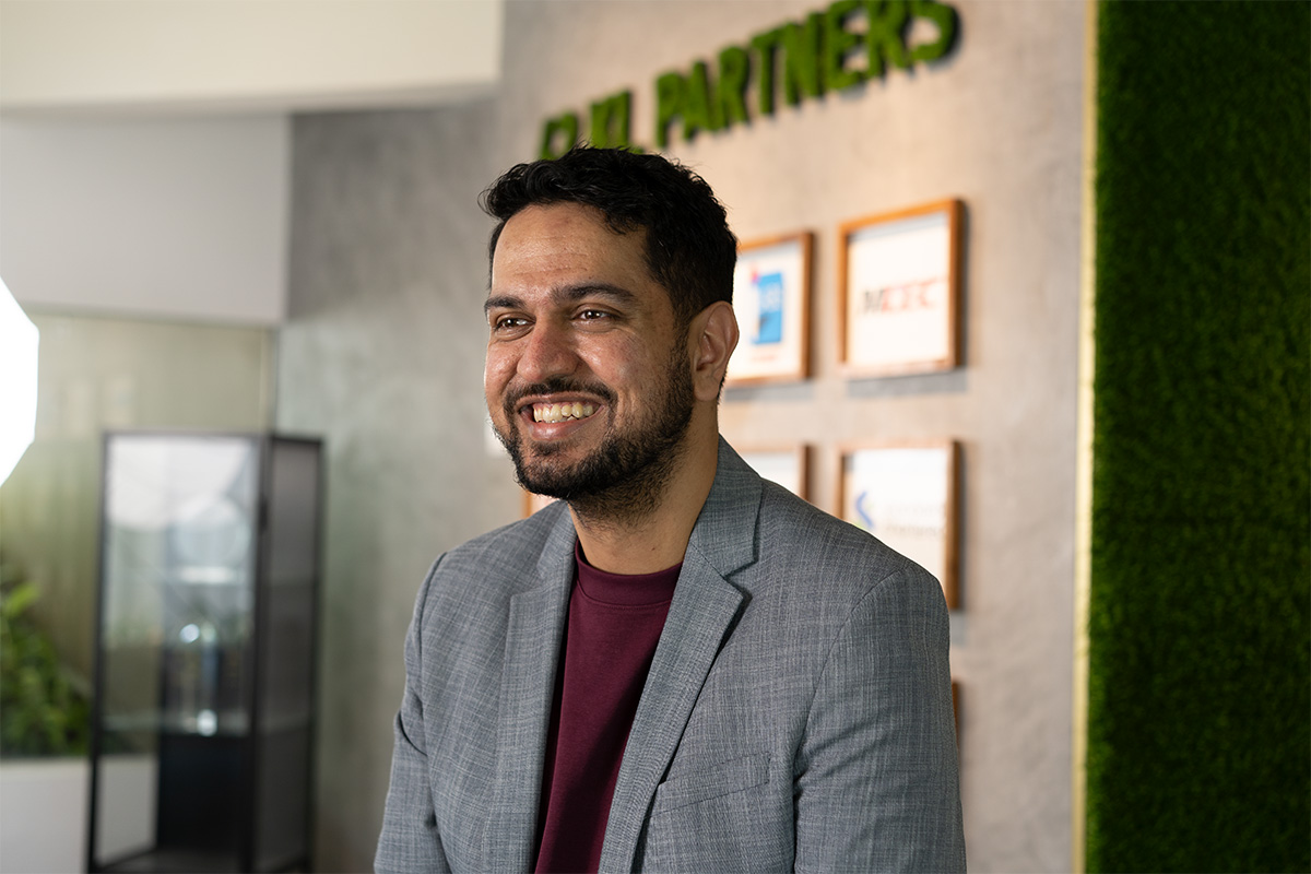 A mid shot of Jeff Sandhu, chief operating officer of 42 Malaysia and head of 42 Kuala Lumpur at Sunway FutureX, donning a grey jacket and purple shirt.