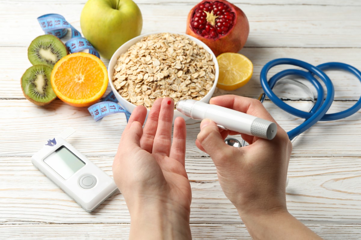 A glucometer test being performed, with fruits and oats in the background