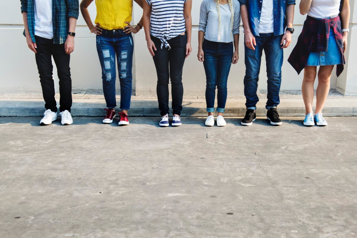 a mid shot of youths from the chest downwards. Wearing denim and youthful attire