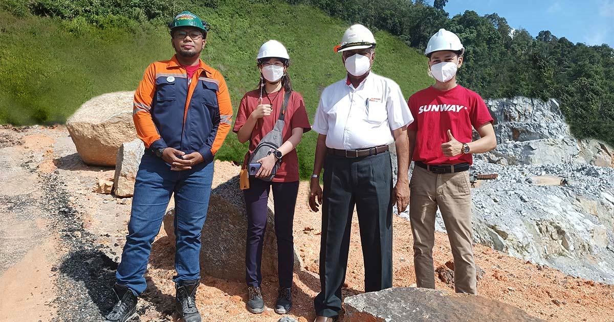 Sunway staff wearing hard hats at a Sunway quarry site, posing with thumbs up for the camera.