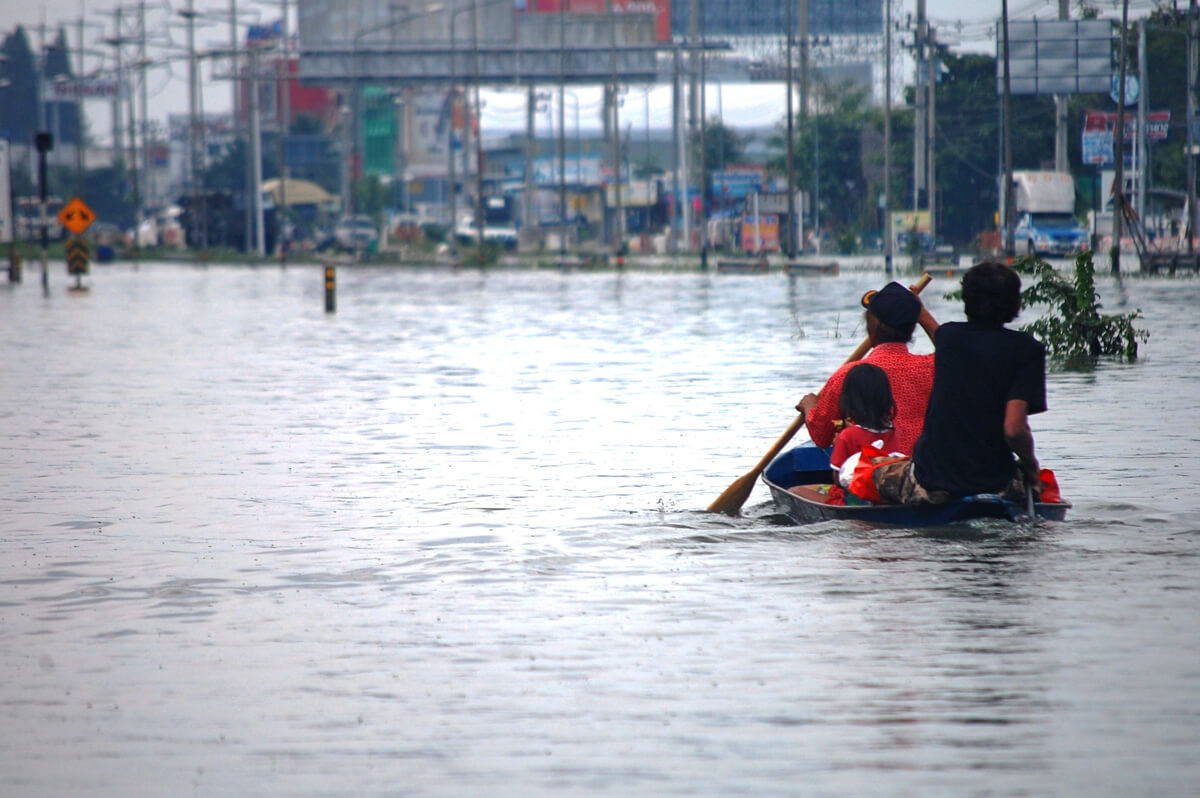 Two men on a kayak in a flooded city
