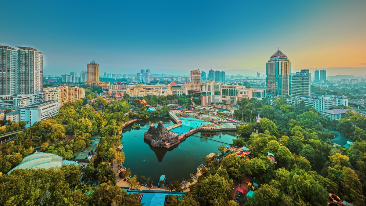 A drone shot of Sunway City Kuala Lumpur at dawn, overseeing the greenery and Sunway Lagoon lake, as well as other Sunway premises.