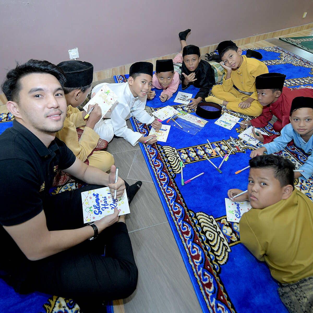 Syahmi Irfan reading alongside children