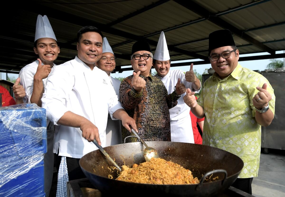 A mid-shot Chef Dato’ Ismail and Bob Yusof cooking alongside chefs at the Selangor Sinar Ramadan event.